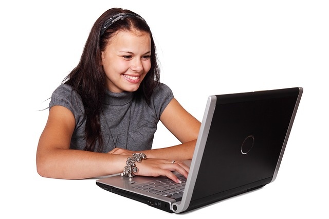 Opiskelija käyttämässä kannettavaa tietokonetta